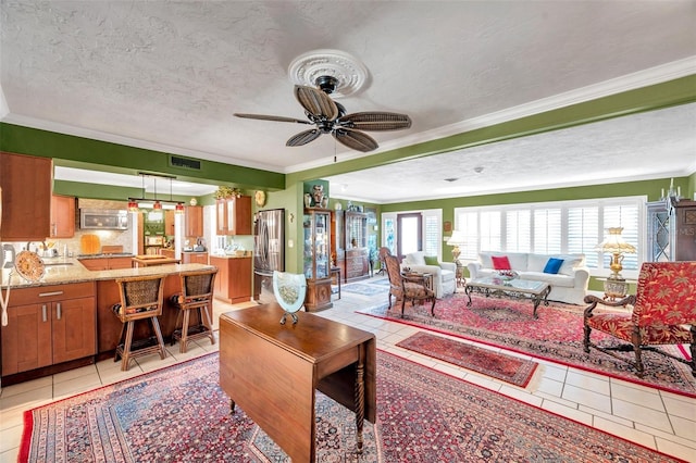 3898 49th Ave S, Saint Petersburg, FL 33711 - living room with light tile patterned floors, a textured ceiling, ornamental molding, and ceiling fan