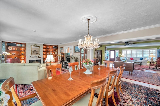 3898 49th Ave S, Saint Petersburg, FL 33711 - tiled dining area featuring a textured ceiling, ornamental molding, a chandelier, a fireplace, and a ceiling fan
