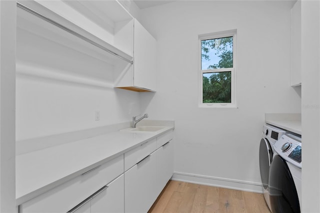 503 W Davis Blvd, Tampa, FL 33606 - laundry area featuring washer and dryer, cabinet space, and light wood-style flooring