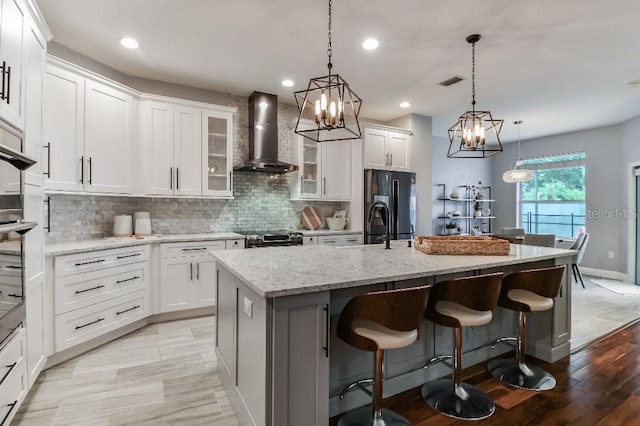 15217 Octavia Ln, Odessa, FL 33556 - kitchen featuring wall chimney range hood, a chandelier, black fridge with ice dispenser, a center island with sink, and tasteful backsplash