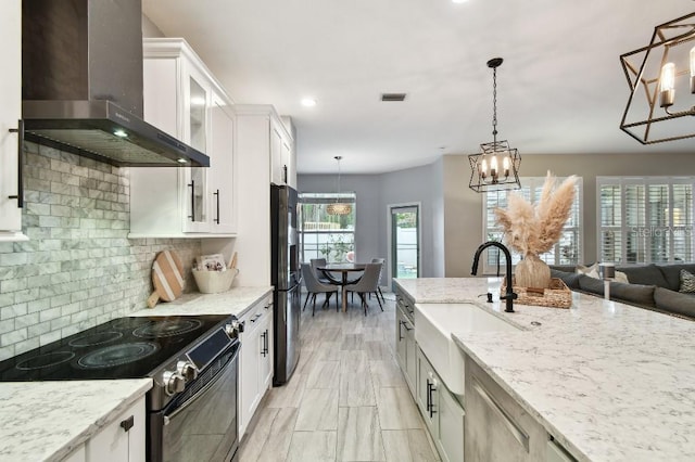 15217 Octavia Ln, Odessa, FL 33556 - kitchen featuring wall chimney range hood, range with electric cooktop, freestanding refrigerator, white cabinetry, and glass insert cabinets