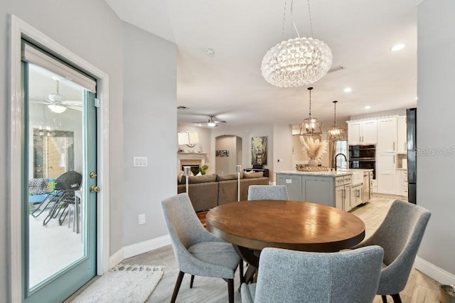 15217 Octavia Ln, Odessa, FL 33556 - dining area featuring ceiling fan, a chandelier, arched walkways, recessed lighting, and light wood-type flooring