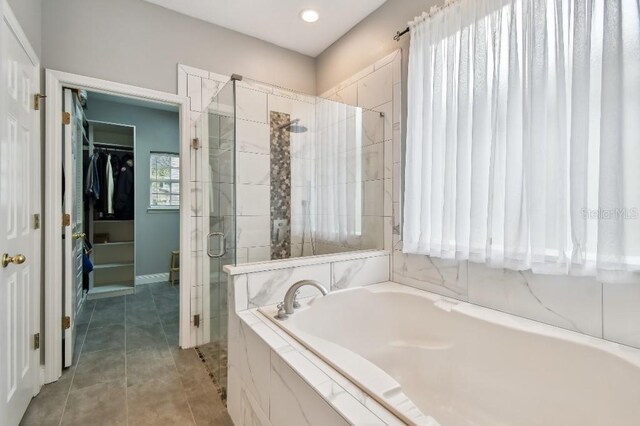 15217 Octavia Ln, Odessa, FL 33556 - bathroom with a spacious closet, a bath, a stall shower, tile patterned floors, and recessed lighting