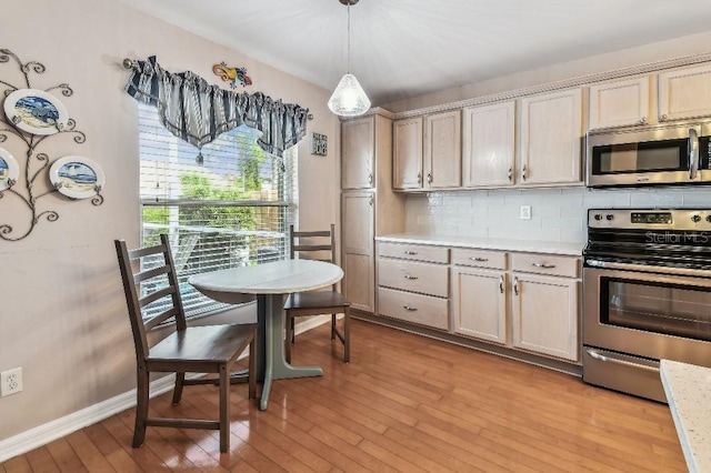 12413 Dawn Vista Dr, Riverview, FL 33578 - kitchen featuring stainless steel appliances, light wood-type flooring, light countertops, backsplash, and decorative light fixtures