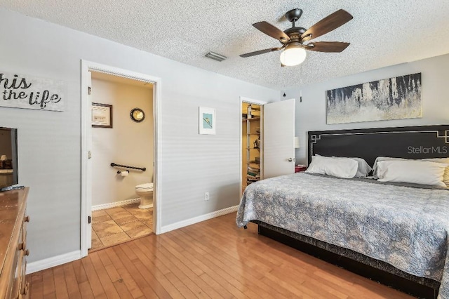 12413 Dawn Vista Dr, Riverview, FL 33578 - bedroom with a textured ceiling, hardwood / wood-style floors, a ceiling fan, connected bathroom, and a spacious closet