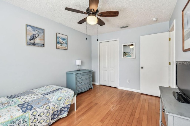 12413 Dawn Vista Dr, Riverview, FL 33578 - bedroom with a textured ceiling, light wood-type flooring, a closet, and ceiling fan