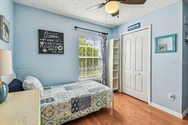 12413 Dawn Vista Dr, Riverview, FL 33578 - bedroom featuring a closet, wood finished floors, a textured ceiling, and a ceiling fan