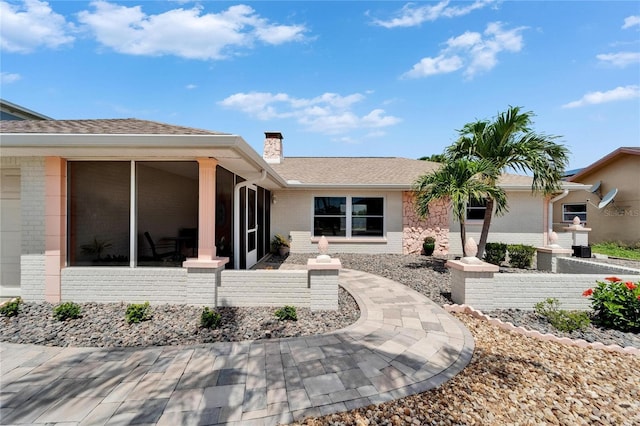 6334 Cocoa Ln, Apollo Beach, FL 33572 - back of property with brick siding, a chimney, a sunroom, and roof with shingles