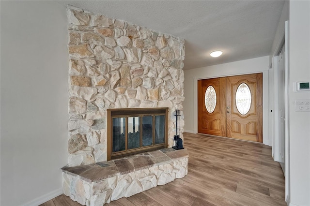 6334 Cocoa Ln, Apollo Beach, FL 33572 - foyer entrance featuring a textured ceiling, wood finished floors, and a stone fireplace