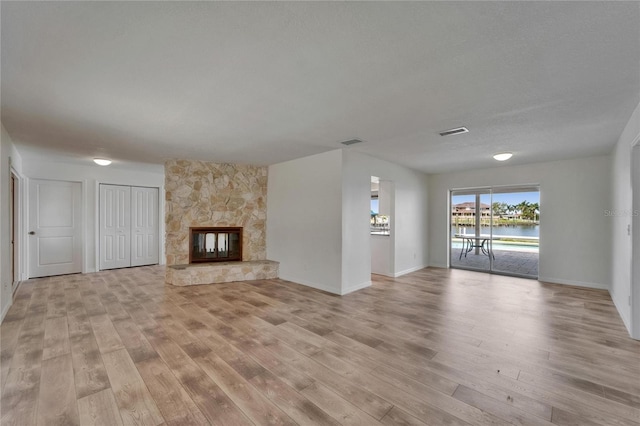 6334 Cocoa Ln, Apollo Beach, FL 33572 - unfurnished living room featuring light wood finished floors, a fireplace, and a water view