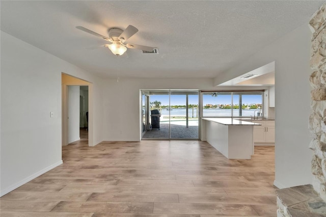 6334 Cocoa Ln, Apollo Beach, FL 33572 - spare room featuring light wood-style floors, a ceiling fan, a textured ceiling, and a water view