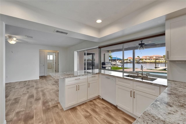 6334 Cocoa Ln, Apollo Beach, FL 33572 - kitchen with dishwasher, a ceiling fan, light wood-style flooring, light stone countertops, and recessed lighting