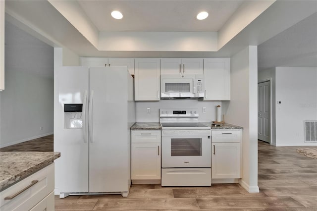 6334 Cocoa Ln, Apollo Beach, FL 33572 - kitchen with white appliances, a tray ceiling, light wood-style flooring, white cabinetry, and recessed lighting