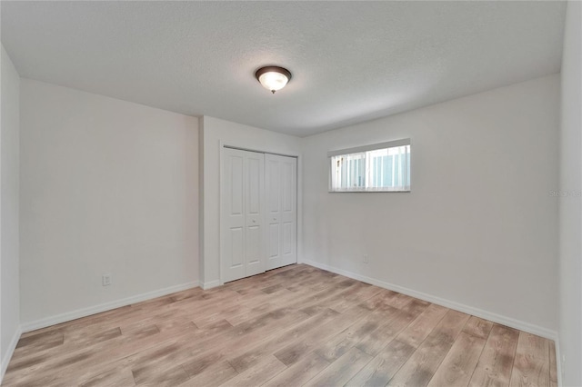 6334 Cocoa Ln, Apollo Beach, FL 33572 - unfurnished bedroom featuring light wood finished floors, a closet, and a textured ceiling