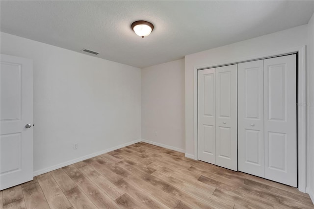 6334 Cocoa Ln, Apollo Beach, FL 33572 - unfurnished bedroom with light wood-style flooring, a closet, and a textured ceiling