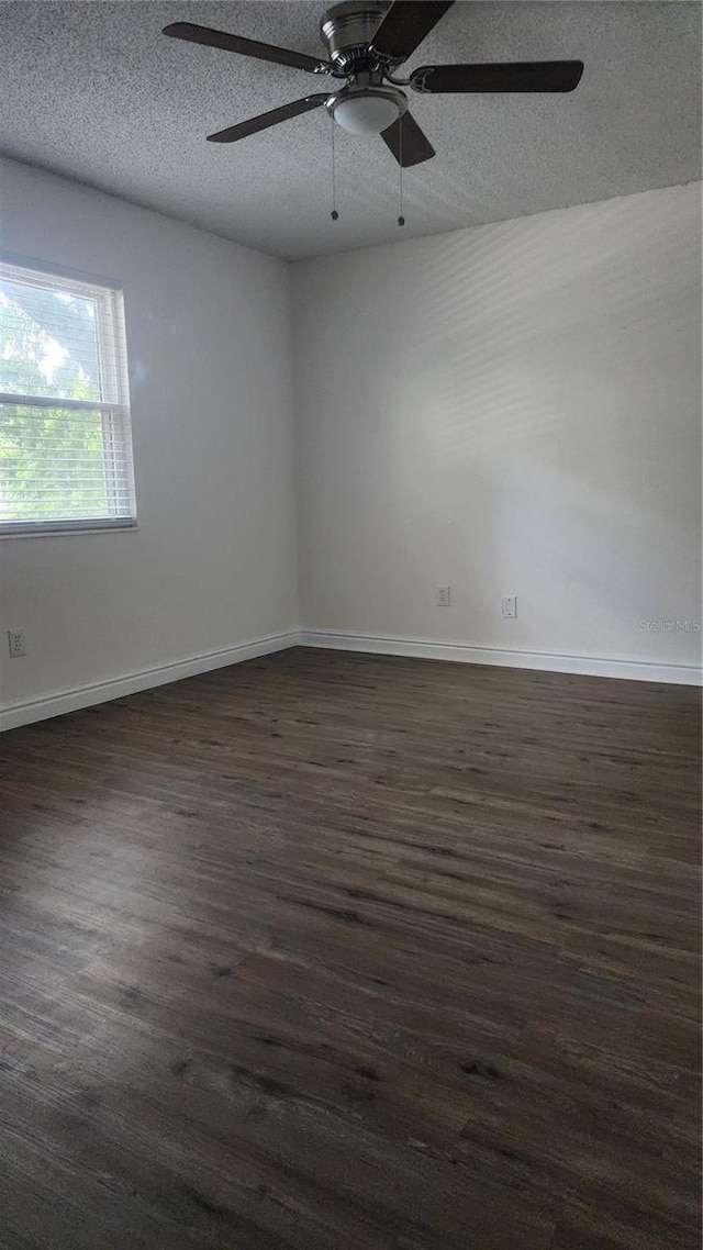 7107 Hernando Ct, Tampa, FL 33615 - unfurnished room featuring a textured ceiling, dark wood-style flooring, and a ceiling fan