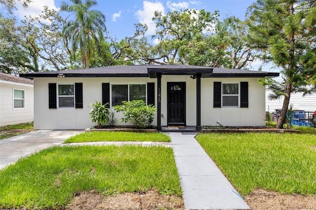 1275 Palm St, Clearwater, FL 33755 - ranch-style home featuring a front yard and stucco siding