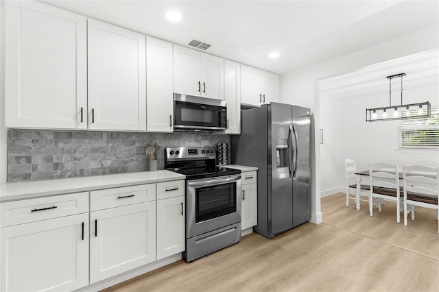 1275 Palm St, Clearwater, FL 33755 - kitchen with stainless steel appliances, light countertops, light wood-style floors, backsplash, and recessed lighting