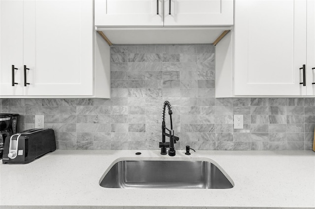 1275 Palm St, Clearwater, FL 33755 - kitchen featuring white cabinets, decorative backsplash, and light stone counters