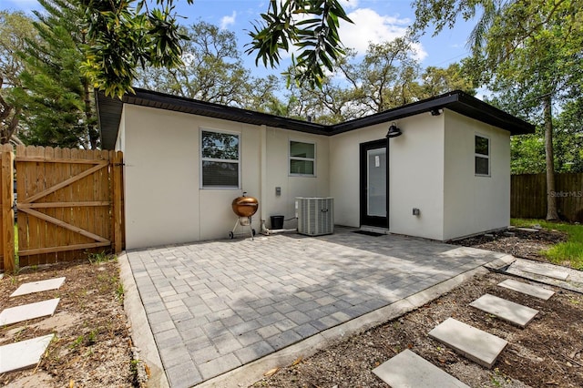1275 Palm St, Clearwater, FL 33755 - rear view of house featuring stucco siding, a patio area, and a gate