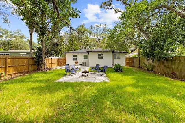 1275 Palm St, Clearwater, FL 33755 - rear view of property featuring a fire pit, a fenced backyard, a patio area, and stucco siding