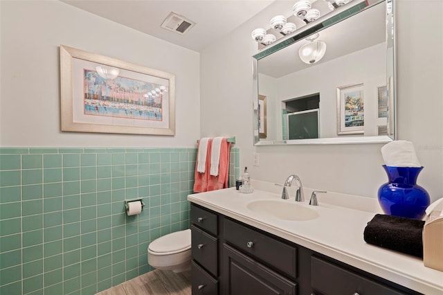 1060 N Shore Dr NE Unit 6, Saint Petersburg, FL 33701 - bathroom featuring vanity, tile walls, a shower with door, wainscoting, and wood finished floors
