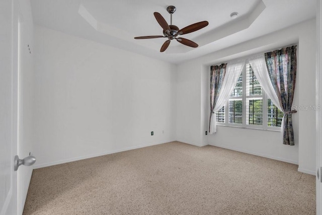6044 Sandhill Ridge Dr, Lithia, FL 33547 - spare room featuring a raised ceiling, light colored carpet, and a ceiling fan