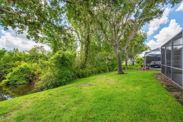 6044 Sandhill Ridge Dr, Lithia, FL 33547 - view of grassy yard with a lanai
