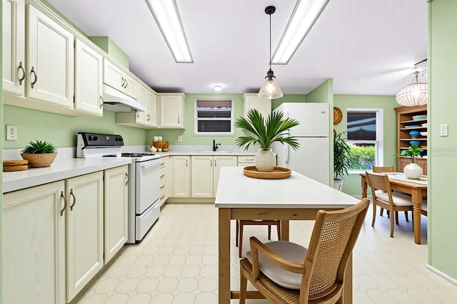 8443 Fantasia Park Way, Riverview, FL 33578 - kitchen with white appliances, under cabinet range hood, light countertops, pendant lighting, and light flooring