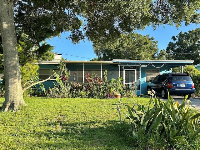 1605 Logan St, Clearwater, FL 33755 - view of front of home with a front lawn and a chimney