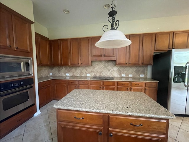 405 Islebay Dr, Apollo Beach, FL 33572 - kitchen featuring stainless steel appliances, light tile patterned floors, brown cabinets, light stone counters, and tasteful backsplash