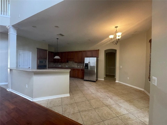 405 Islebay Dr, Apollo Beach, FL 33572 - kitchen with stainless steel appliances, arched walkways, light countertops, decorative backsplash, and a chandelier