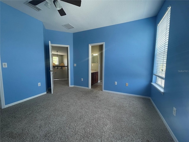 405 Islebay Dr, Apollo Beach, FL 33572 - unfurnished bedroom featuring carpet flooring, a ceiling fan, ensuite bath, and a textured ceiling