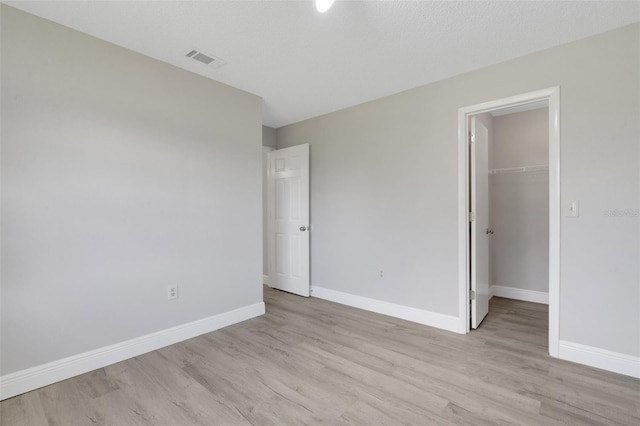 2151 Groveglen Ln S, Lakeland, FL 33813 - unfurnished bedroom featuring light wood-style floors, a walk in closet, and a closet