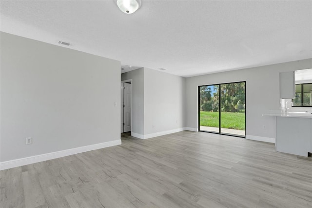 2151 Groveglen Ln S, Lakeland, FL 33813 - unfurnished living room featuring light wood finished floors and baseboards