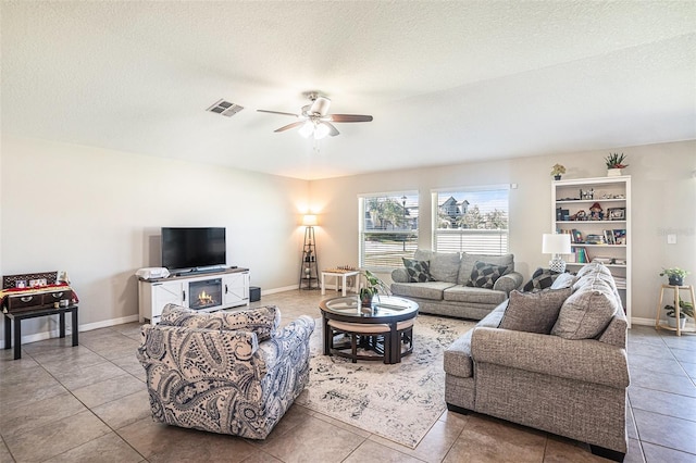 10211 Cakebread Ln, Riverview, FL 33578 - tiled living room featuring a ceiling fan, a textured ceiling, and a fireplace
