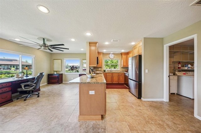 2110 W View Dr, Sun City Center, FL 33573 - kitchen featuring appliances with stainless steel finishes, washer / clothes dryer, a peninsula, an office area, and light stone countertops