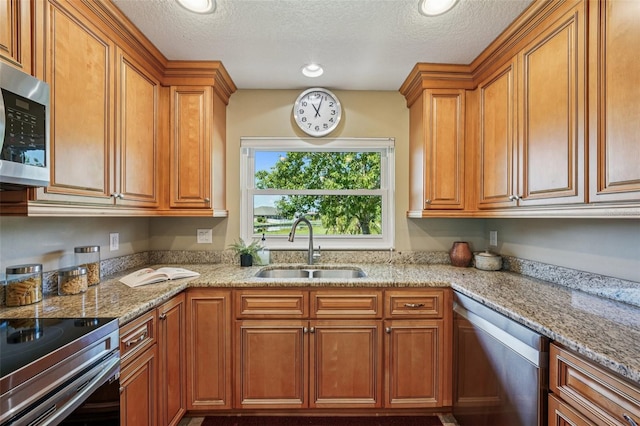 2110 W View Dr, Sun City Center, FL 33573 - kitchen featuring stainless steel appliances, brown cabinets, light stone counters, a textured ceiling, and recessed lighting
