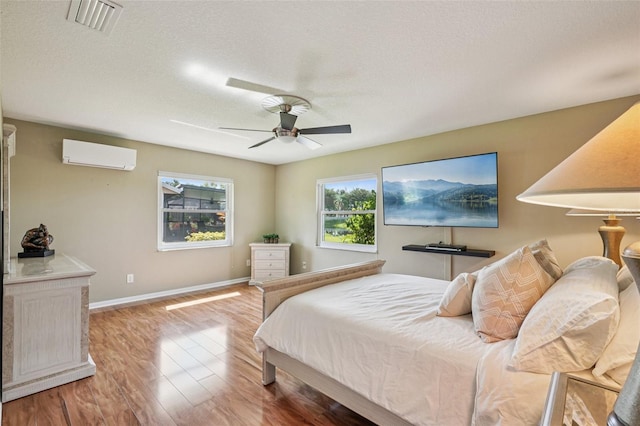 2110 W View Dr, Sun City Center, FL 33573 - bedroom featuring a wall mounted AC, wood finished floors, a ceiling fan, and a textured ceiling