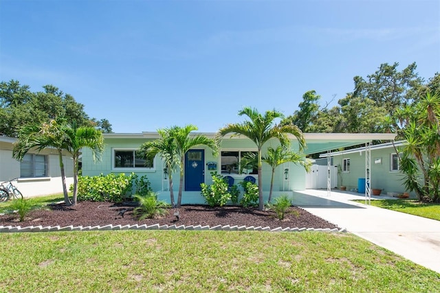 4718 24th Ave S, Saint Petersburg, FL 33711 - view of front facade with concrete driveway, a front yard, and a carport