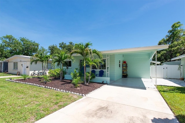4718 24th Ave S, Saint Petersburg, FL 33711 - view of front facade with a gate, driveway, and a carport