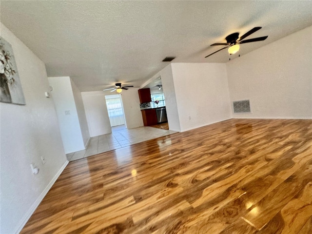 3902 Glissade Dr, New Port Richey, FL 34652 - unfurnished living room featuring light wood-style floors, ceiling fan, and a textured ceiling