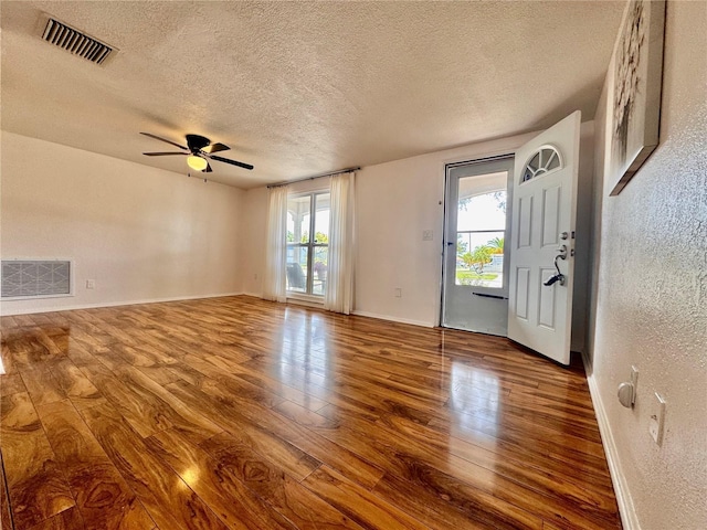 3902 Glissade Dr, New Port Richey, FL 34652 - spare room with wood finished floors, a textured ceiling, a textured wall, and a ceiling fan
