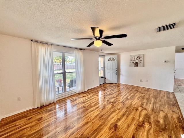 3902 Glissade Dr, New Port Richey, FL 34652 - empty room with wood finished floors, a ceiling fan, and a textured ceiling