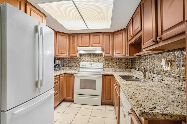 2270 Spruce Ln Unit B, Palm Harbor, FL 34684 - kitchen with white appliances, under cabinet range hood, light tile patterned flooring, and tasteful backsplash