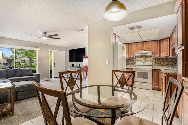 2270 Spruce Ln Unit B, Palm Harbor, FL 34684 - dining space with ceiling fan, light tile patterned floors, and a textured ceiling