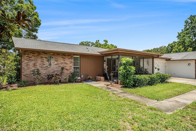 2270 Spruce Ln Unit B, Palm Harbor, FL 34684 - view of front of home featuring an attached garage, a front lawn, a sunroom, concrete driveway, and brick siding