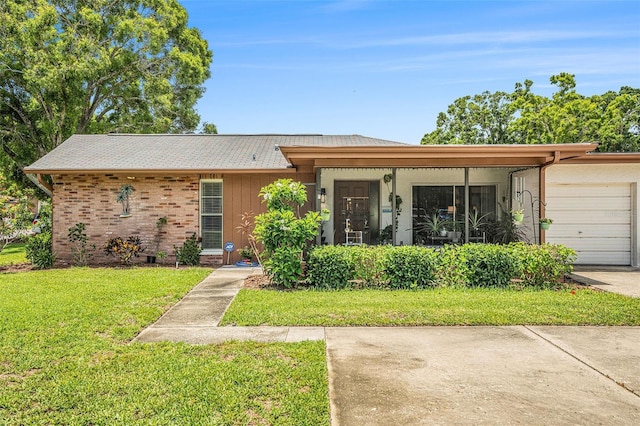2270 Spruce Ln Unit B, Palm Harbor, FL 34684 - view of front of house with a front lawn, an attached garage, driveway, and brick siding