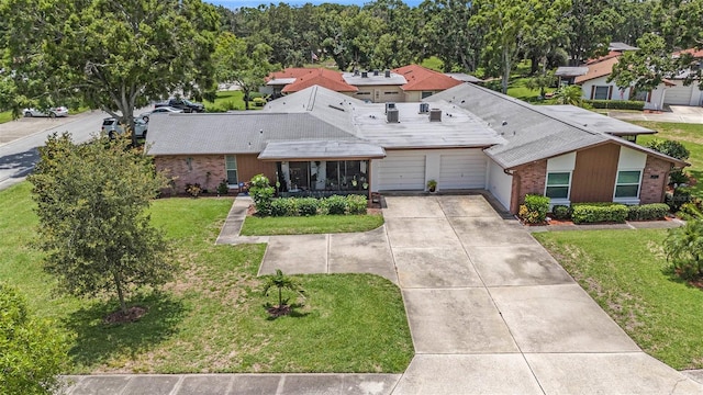 2270 Spruce Ln Unit B, Palm Harbor, FL 34684 - view of front of property with a garage, brick siding, concrete driveway, and a front yard