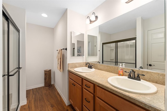 1032 Kelsea Cir, The Villages, FL 32159 - full bathroom with wood finished floors, double vanity, and an enclosed shower